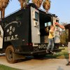 Tom Sippel helps his son Liam out of the SWAT truck.